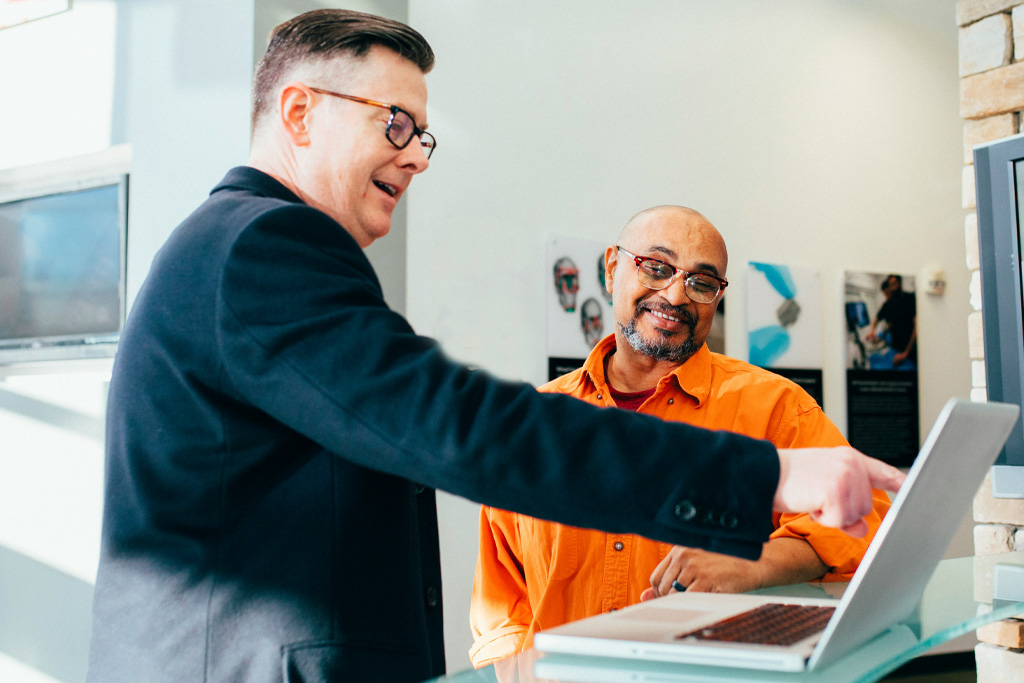 Två kommunala revisorer diskuterar och pekar på en datorskärm.