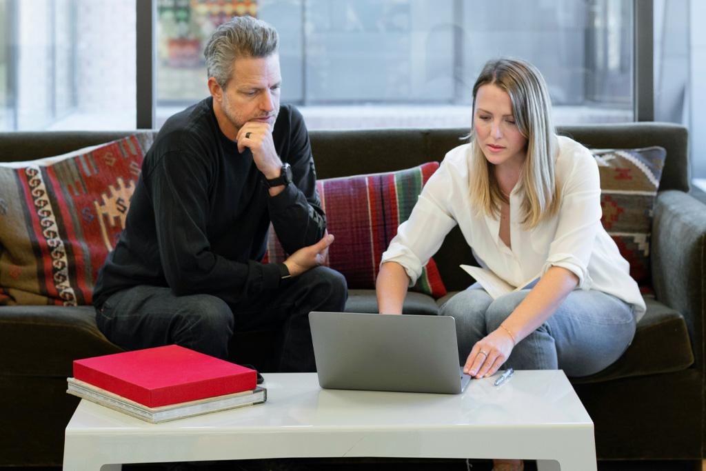 Två kommunala revisorer diskuterar vid en dator.