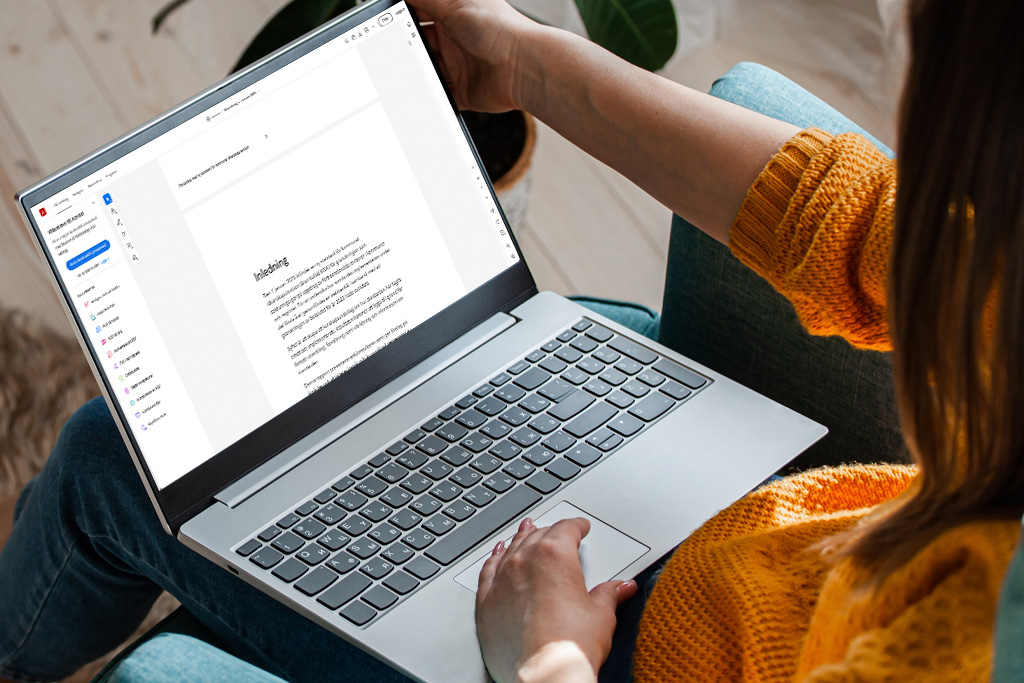 En revisor sitter och läser ett utvärderingsdokument i sin dator.