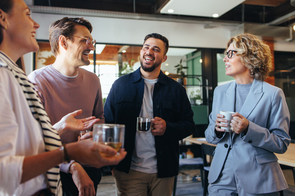 Några kommunala revisorer pratar glatt med varandra över en kafferast.